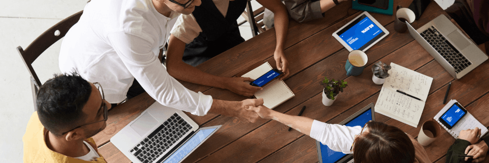 Cross-functional team meeting in a collaborative workspace, illustrating stabilisation, governance reset, and refocused delivery.